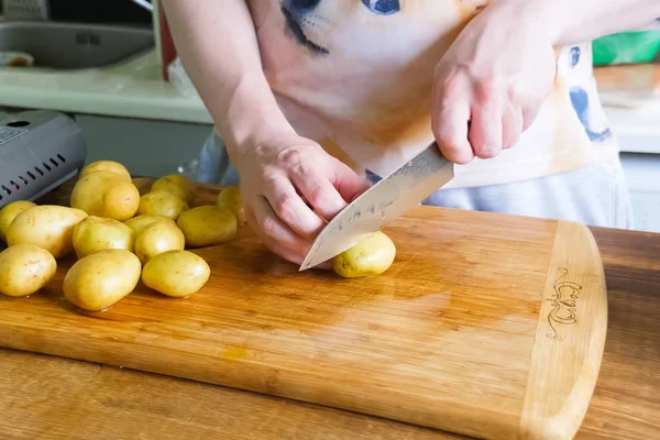 Rauwe aardappelen snijden en schillen op tafel in een plaat — Stockfoto
