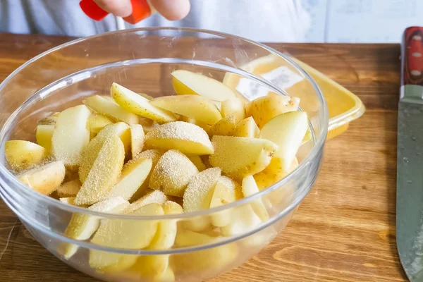 Rauwe aardappelen snijden en schillen op tafel in een plaat — Stockfoto