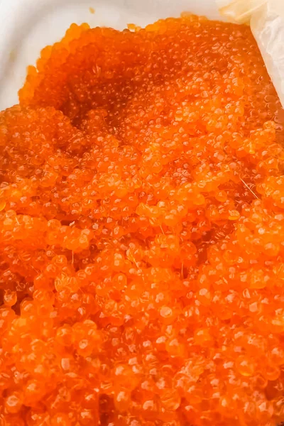 Caviar rojo en un recipiente de plástico. Caviar de salmón, comida dietética . — Foto de Stock