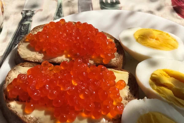Sandwich con caviar rojo y huevos cocidos, taza de café. Buenos días. — Foto de Stock