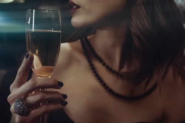 Vrouw houdt glas champagne bij de lippen. — Stockfoto