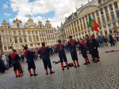 Brüksel, Belçika. Juy, 2016. Bir grup Portekizli üniversite öğrencisi Brüksel 'in Grand Place' inde enstrüman çalıp şarkı söylüyor ve büyük bir Portekiz bayrağı sallıyorlar. Üniversite orkinos üyeleri.