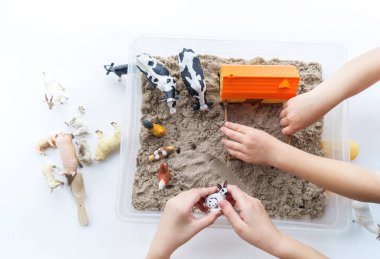 Montessori kumaşı. Çocuk elleri bir hayvan figürünü canlandırıyor. Kinetik kum