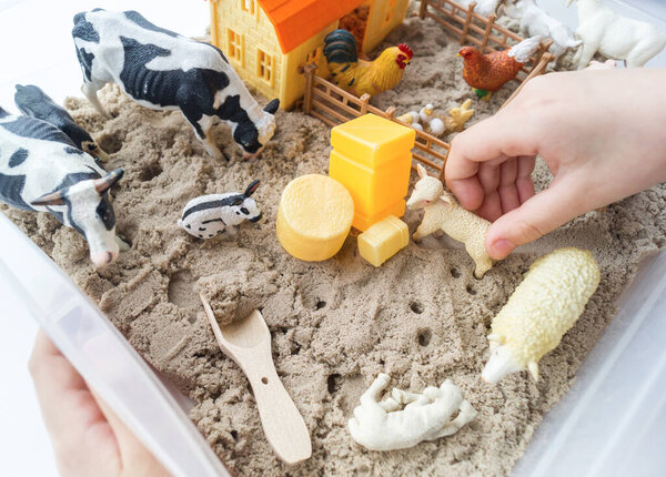 Материал Монтессори. Детские руки играют фигуру животного. Кинетический песок
