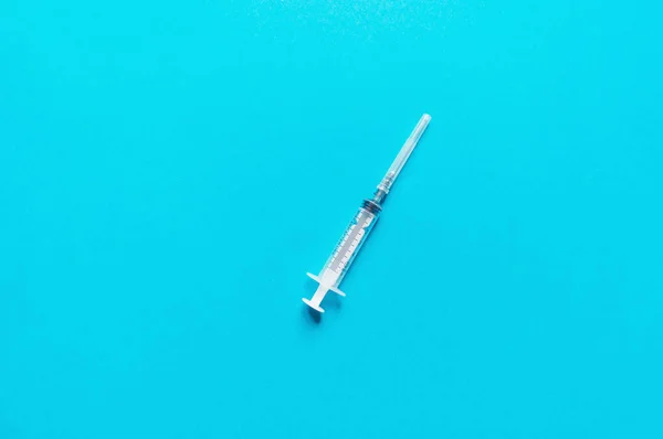 Syringe on a blue background. — Stock Photo, Image