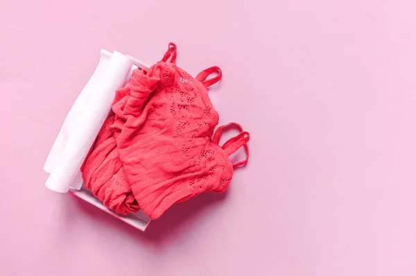 Erotisk kostym av röd färg i ett nät. Rosa bakgrund. — Stockfoto
