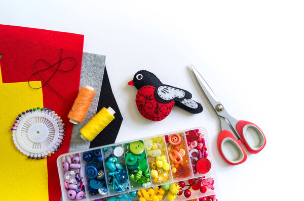 We sew a toy bullfinch from felt. New Year bird symbol.