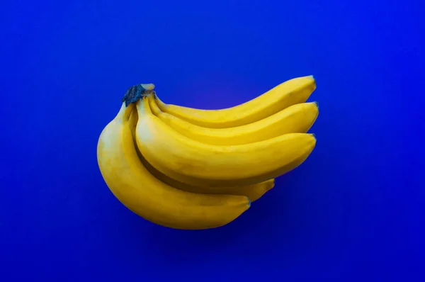 Concepto azul de moda. Manojo de plátanos amarillos Color del año 2020 . — Foto de Stock