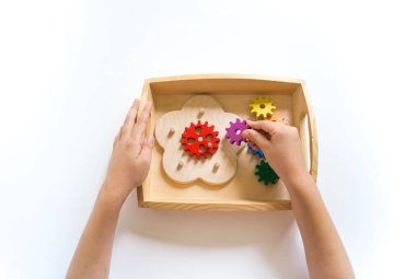 Montessori malzemesi. Bir çocuğun elleri oynuyor..