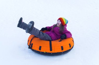 happy child riding on the tubing . inflatable sledges