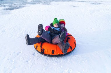 happy child riding on the tubing . inflatable sledges. Boy and girl