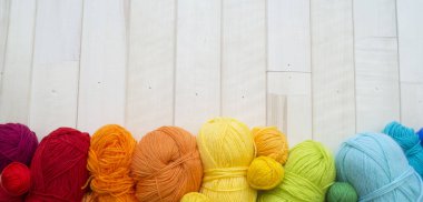 Yarn for knitting rainbow. Wood background.