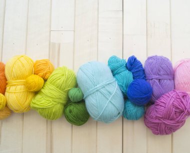 Yarn for knitting rainbow. Wood background.