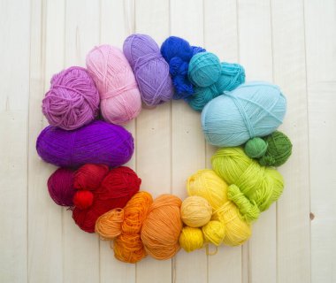 Yarn for knitting rainbow. Wood background.