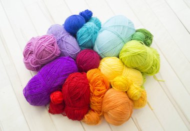 Yarn for knitting rainbow. Wood background.
