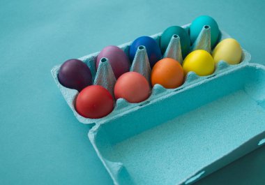 Paskalya yumurtaları gökkuşağının rengidir. Mavi arkaplan.