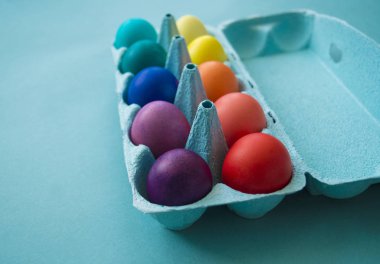 Paskalya yumurtaları gökkuşağının rengidir. Mavi arkaplan.