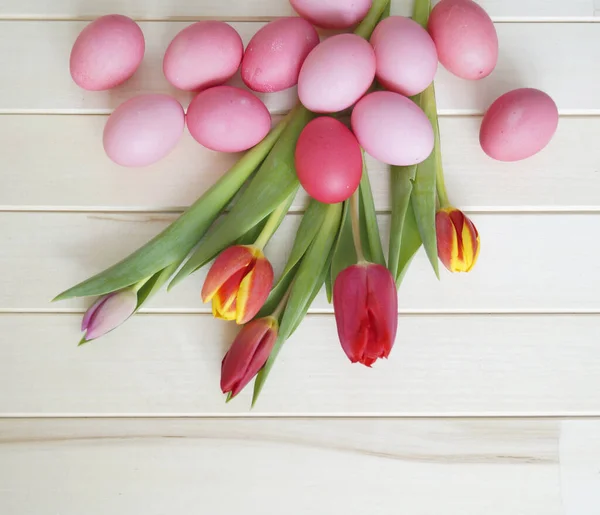 Easter holiday tulips and pink eggs. — Stock Photo, Image