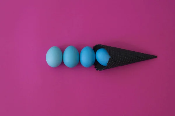 The eggs roll out of the black horn. Pink background. — Stockfoto