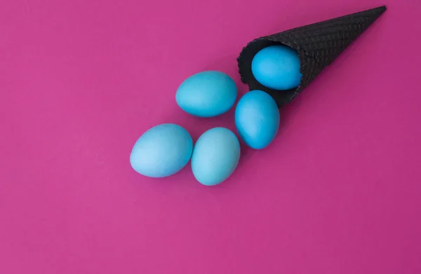 卵は黒い角から転がる。ピンクの背景. — ストック写真