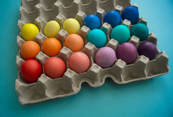 Easter eggs are the color of the rainbow. Blue background. — 스톡 사진