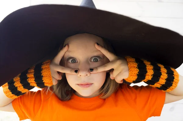 Malá dívka v kostýmu čarodějnice hraje na podzim. — Stock fotografie