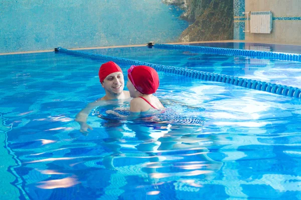 O pai ensina a filha a nadar na piscina. Uma criança aprende a nadar seção de esportes . — Fotografia de Stock