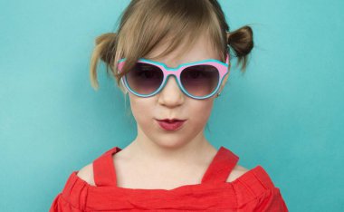 Child in glasses a blue background.