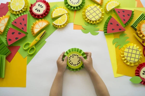 Fruta hecha de papel artesanal. Manos de niños . — Foto de Stock