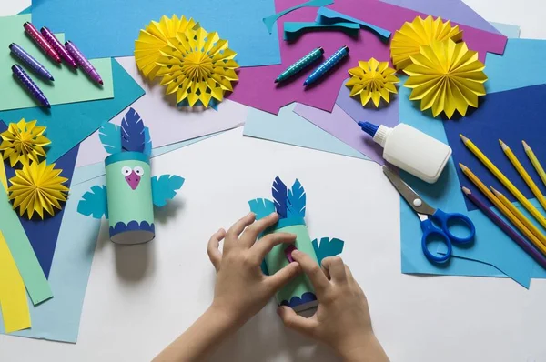 A bird made of paper. Blue bird. Hands of a child. Master Class. craftsmanship