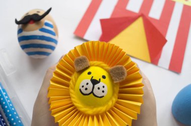 Paskalya tatili. Çocukların elleri yumurta boyar. Dekorun masadaki hazırlığı.