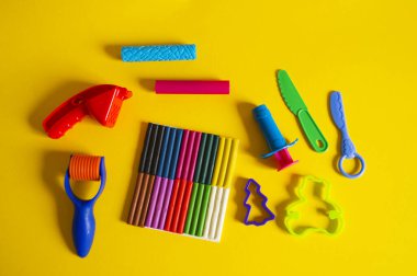 Yaratıcı hobiler için aletler. Plasticin yığını şekilli merdane kalıbı. Kolay eğitim okulu anaokulu. Sarı arkaplan.