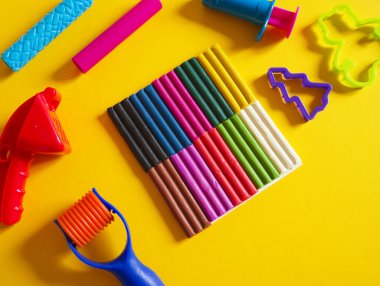 Yaratıcı hobiler için aletler. Plasticin yığını şekilli merdane kalıbı. Kolay eğitim okulu anaokulu. Sarı arkaplan.