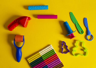 Yaratıcı hobiler için aletler. Plasticin yığını şekilli merdane kalıbı. Kolay eğitim okulu anaokulu. Sarı arkaplan.