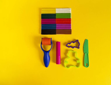 Yaratıcı hobiler için aletler. Plasticin yığını şekilli merdane kalıbı. Kolay eğitim okulu anaokulu. Sarı arkaplan.