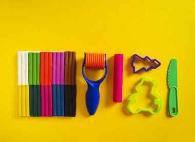 Yaratıcı hobiler için aletler. Plasticin yığını şekilli merdane kalıbı. Kolay eğitim okulu anaokulu. Sarı arkaplan.
