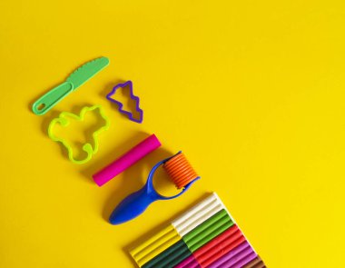 Yaratıcı hobiler için aletler. Plasticin yığını şekilli merdane kalıbı. Kolay eğitim okulu anaokulu. Sarı arkaplan.