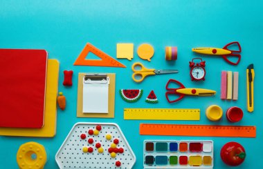 Mavi arka planda okul malzemeleri. Okula dönelim. Anaokulu. Çocuklarla yaratıcılığa hazır. Çocuk dersini alır..