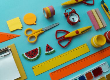 Mavi arka planda okul malzemeleri. Okula dönelim. Anaokulu. Çocuklarla yaratıcılığa hazır. Çocuk dersini alır..