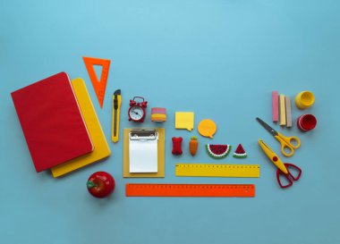 Mavi arka planda okul malzemeleri. Okula dönelim. Anaokulu. Çocuklarla yaratıcılığa hazır. Çocuk dersini alır..