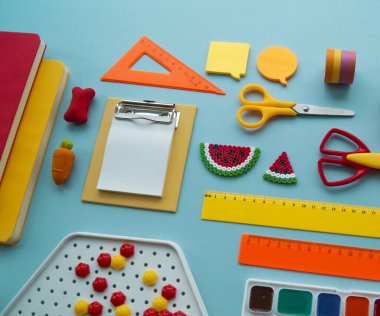 Mavi arka planda okul malzemeleri. Okula dönelim. Anaokulu. Çocuklarla yaratıcılığa hazır. Çocuk dersini alır..