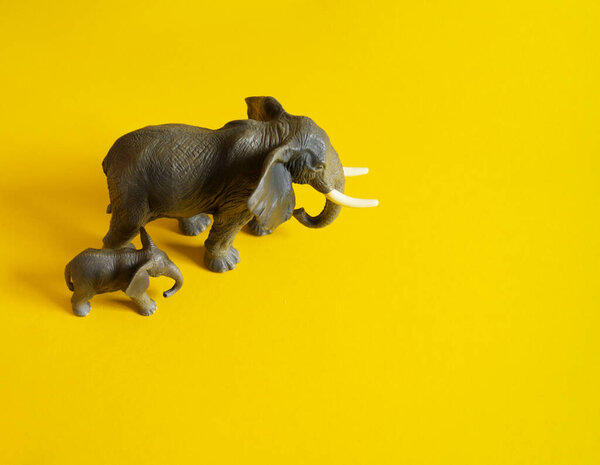 Plastic figurines of animals in hot countries. Protection of the animal. Children's toy. Yellow background.