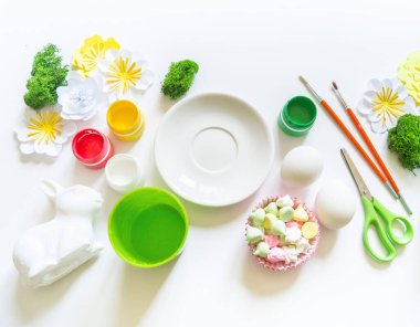 Paskalya yumurtasını boya. Suluboya lekeleri ve fırçalar. Moda rengi sarı ve pembe. Tavşan hediyeleri