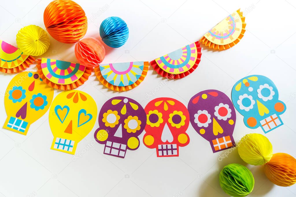 Holiday Cinco de mayo Mexican. Decoration for the festival. Garland skull painted with patterns. Hands of a child.