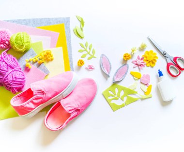 Pembe spor ayakkabıları diy. Paskalya tatili tavşanı. Çocuk elleri. Yaratıcılık için malzeme. Tasarımcı ayakkabıları.