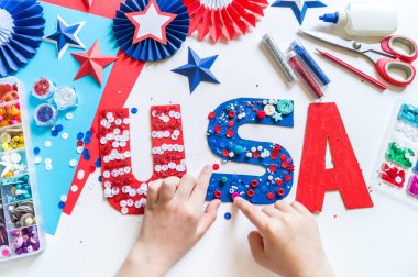 4 Temmuz, ABD harfleri Amerikan bayrağını renklendiriyor. Vatansever bayram. İşlemci çocuk işi. Havai fişekli roket