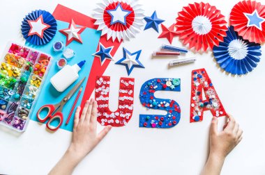 4 Temmuz, ABD harfleri Amerikan bayrağını renklendiriyor. Vatansever bayram. İşlemci çocuk işi. Havai fişekli roket