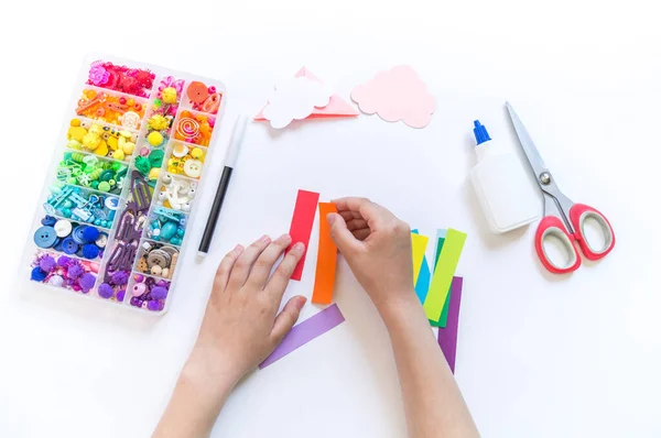 一本儿童读物到学校的书签 Origami纸制工艺与儿童的手 来自云彩的明亮彩虹 — 图库照片