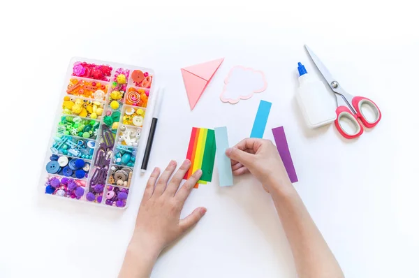 学校への児童書のブックマーク 子どもの手で折り紙の紙工芸品 雲からの明るい虹 — ストック写真
