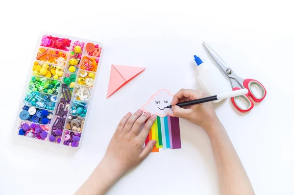 学校への児童書のブックマーク 子どもの手で折り紙の紙工芸品 雲からの明るい虹 — ストック写真